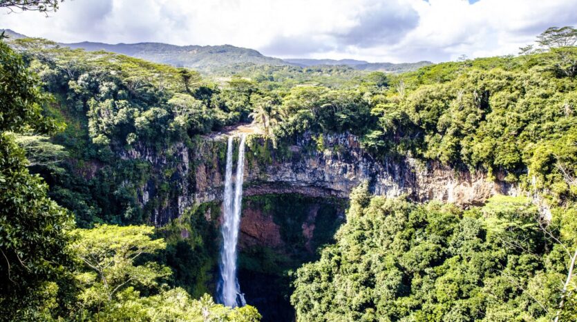 Crystal-clear waterfall flowing into a tranquil turquoise pool at 27 Charcos in the Dominican Republic