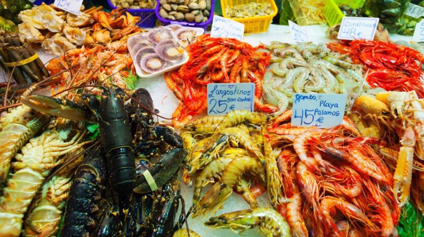 Fresh Dominican seafood platter with grilled lobster, shrimp, and fried fish served by the beach.