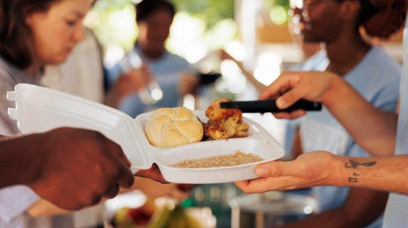 Traditional Dominican street food stall serving empanadas, chimis, and tostones in a busy local market.