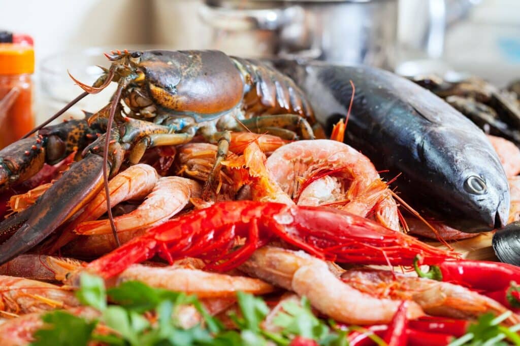 Grilled Dominican seafood cooking over open flames at a beachside food shack.