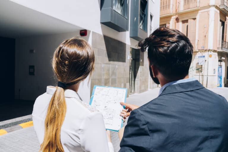 Architect reviewing blueprints with local officials during a building permit application process in the Dominican Republic.
