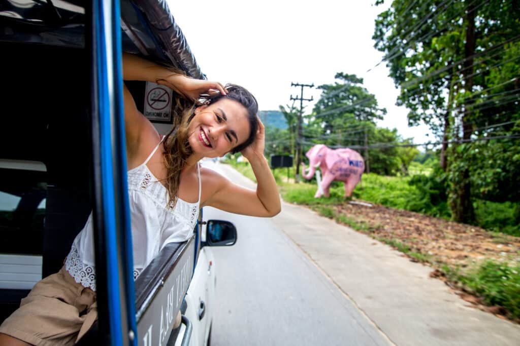 Crowded guagua (minibus) picking up passengers in a Dominican Republic neighborhood.