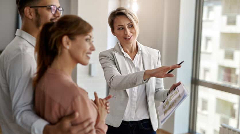 Real estate agent showing property listings in a modern office in Santiago, Dominican Republic.