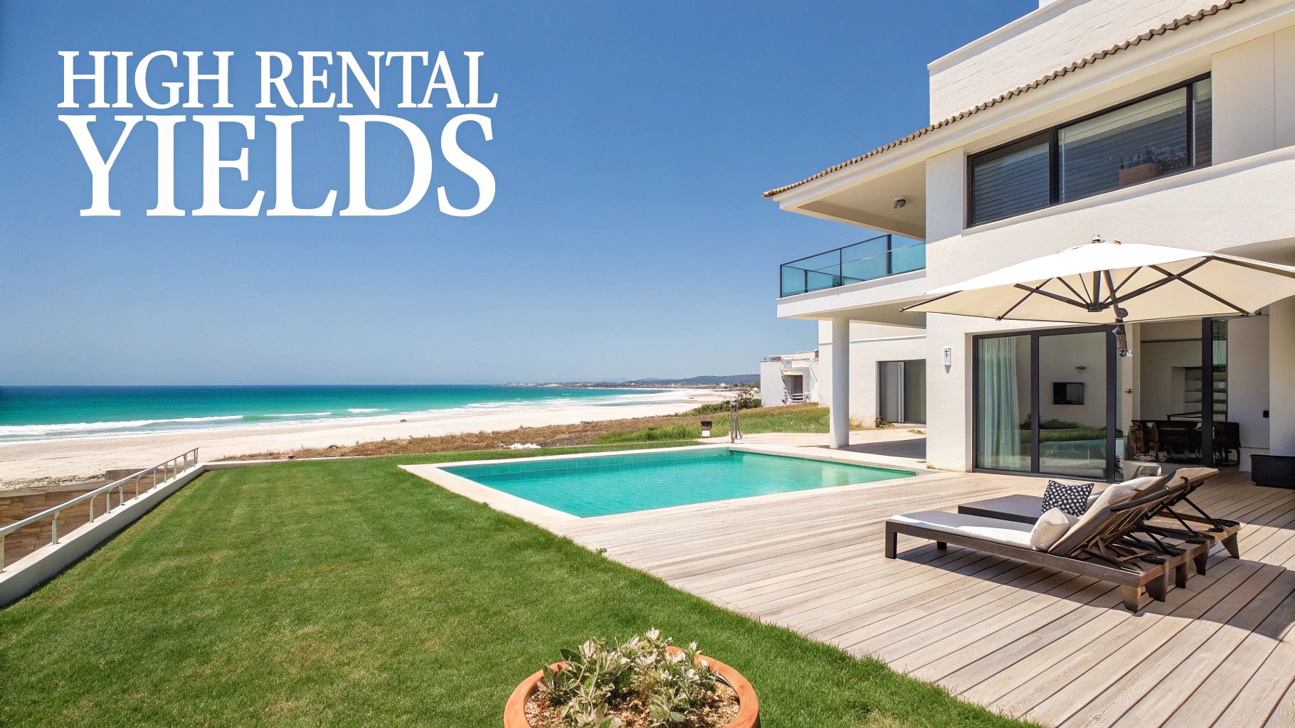 A luxurious beachfront house with a swimming pool, green lawn, and sandy beach leading to a turquoise ocean.