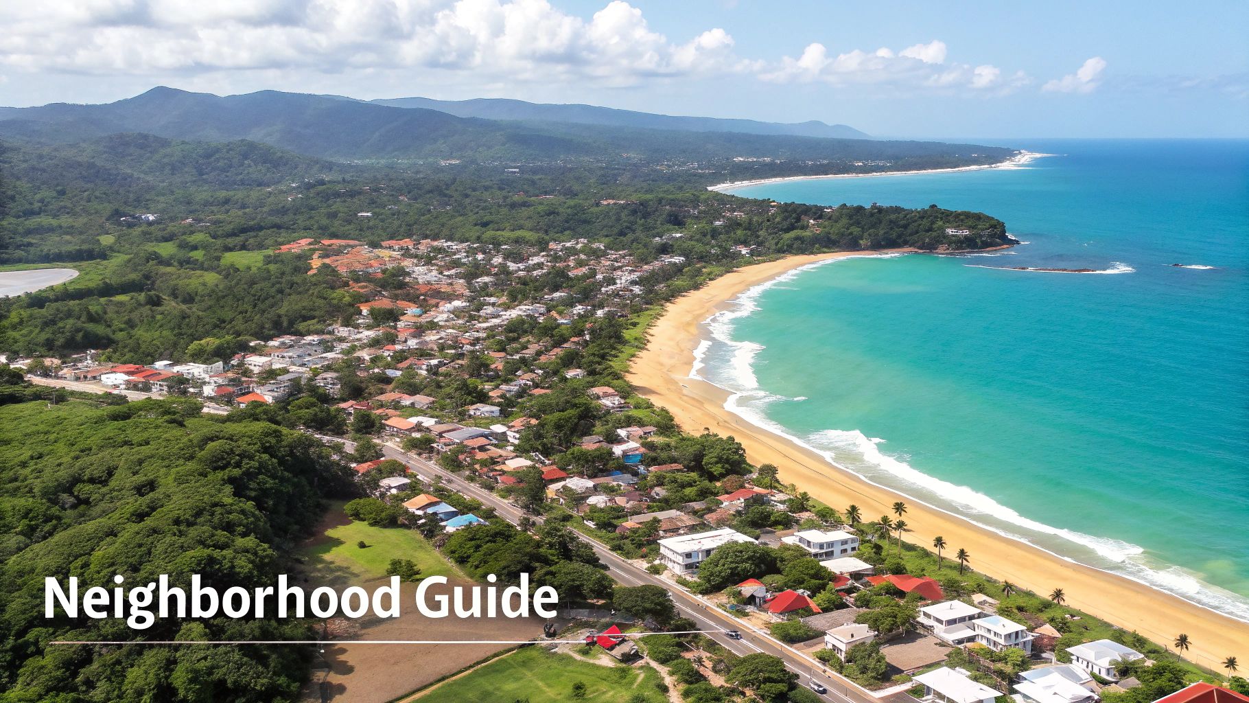 Panoramic aerial shot of a vibrant coastal town featuring a sandy beach, blue ocean, and lush mountains.