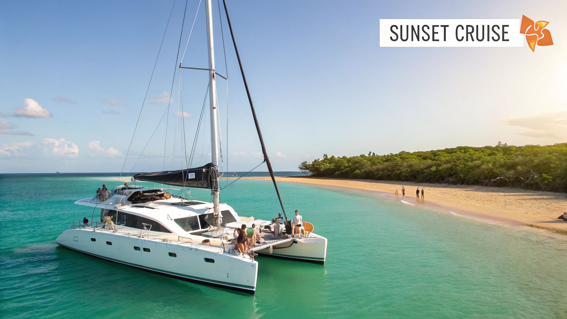 A large white catamaran full of people anchored in clear turquoise water next to a tropical sandy beach.